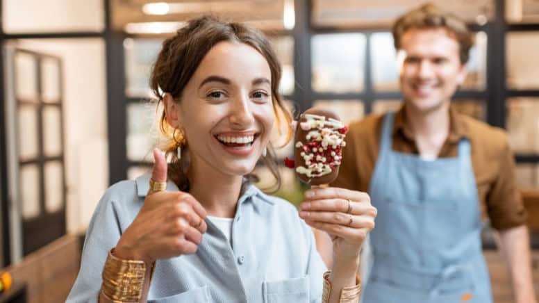 Une cliente heureuse qui montre sa satisfaction sur la qualité de service d'un salon de thé