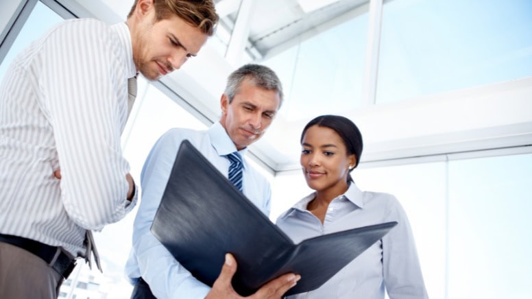 Des directeurs d'entreprise qui étudient les dossiers de plusieurs auditeurs ISO 9001