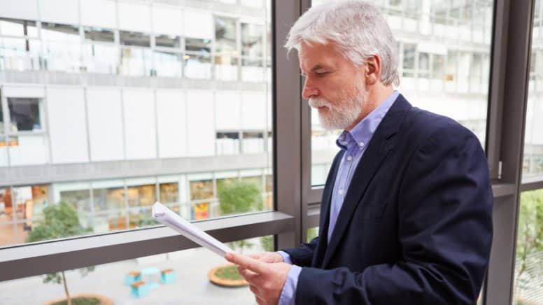 Un homme en train de lire une revue de direction en vue d'un audit ISO