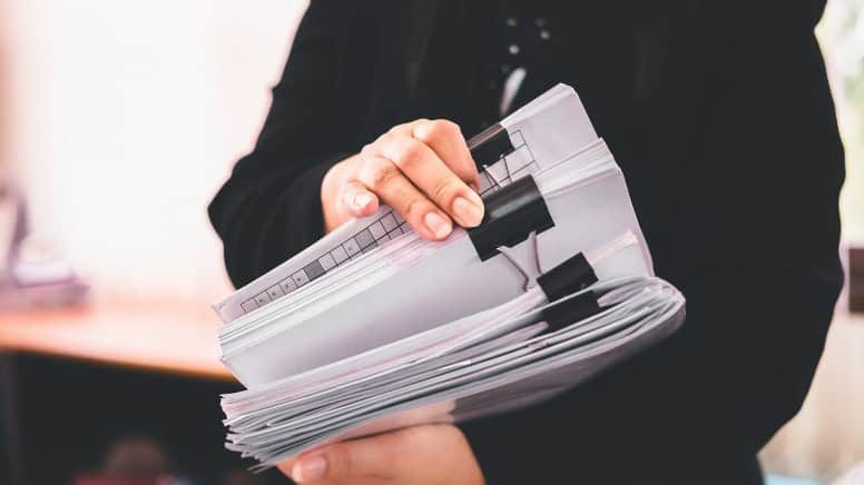 Une personne en train de vérifier des documents relatifs à la norme ISO 45001