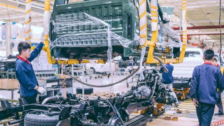 Des ouvriers de production automobile respectant les normes d'assemblage