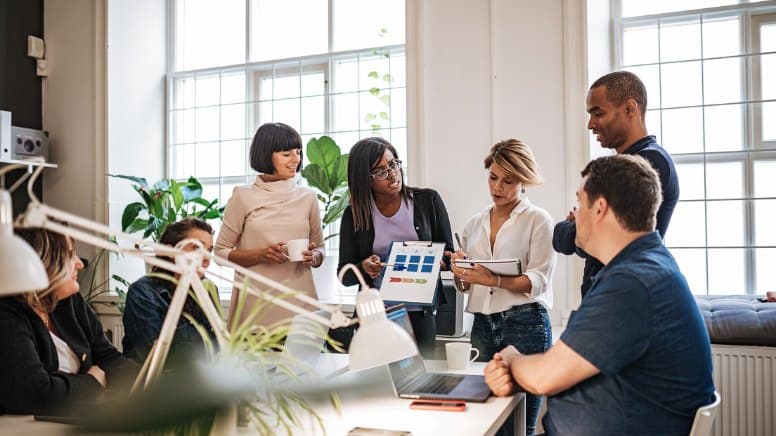 Une équipe en réunion avec un consultant pour optimiser les processus internes d'une entreprise