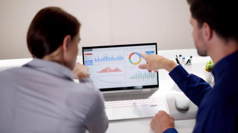 Deux personnes qui analysent les données d'un tableau de bord pour un audit