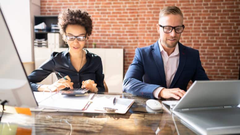 Une équipe qui calcule les réductions de coût liées à l'ISO 45001