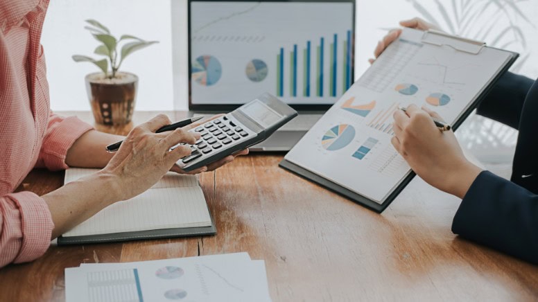 Des dirigeants d'entreprise qui calculent les économies réalisées grâce à la norme EN 9100